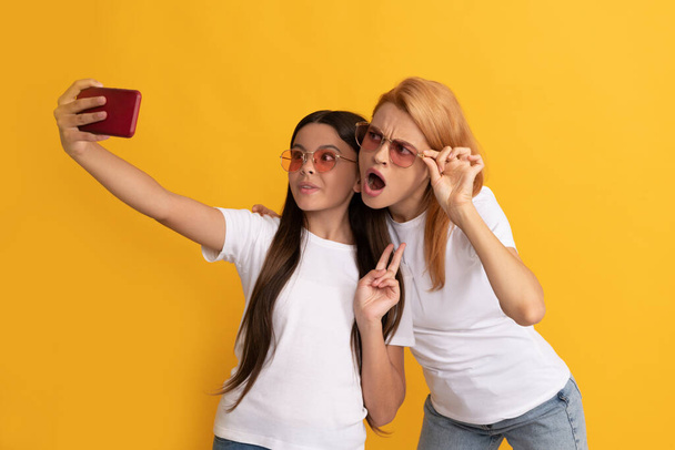 alegre madre e hija haciendo selfie en smartphone, autofoto familiar - Foto, imagen