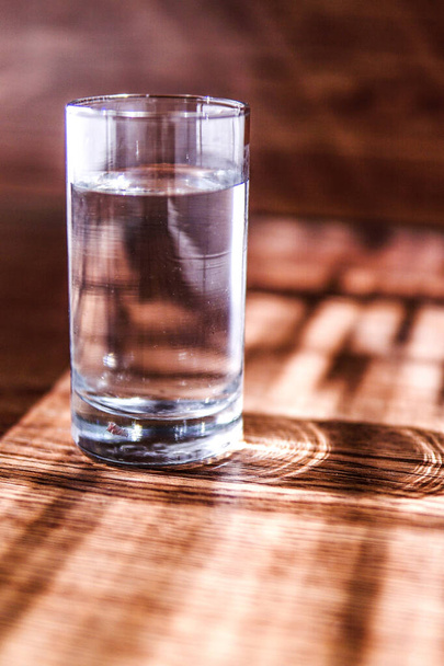 A glass of water in a wooden table - Foto, afbeelding