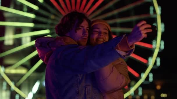Hymyilevä pari ottaa selfie älypuhelimella. Mies ja nainen virnistelevät kameran edessä. - Materiaali, video