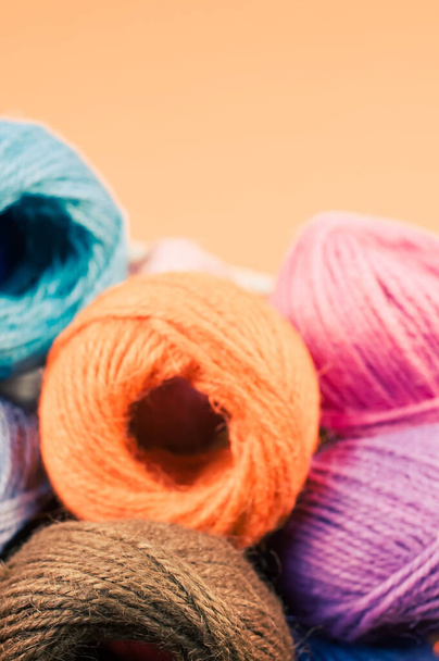 A basket full of colorful yarn rolls isolated on an orange background with free space for text - Zdjęcie, obraz