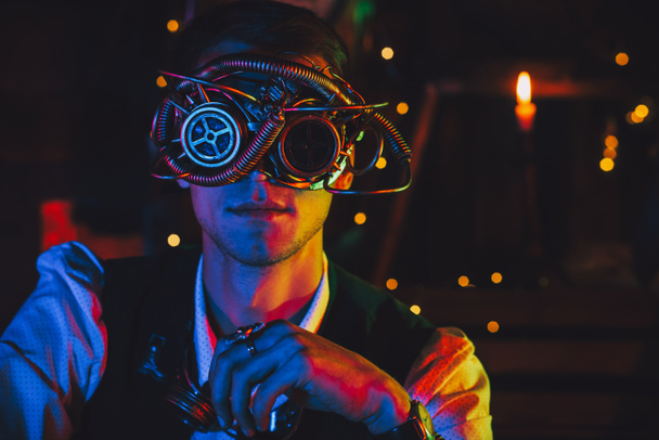 ritratto di un ingegnere maschio con occhiali cyberpunk e tuta steampunk in un laboratorio - Foto, immagini