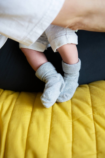Breastfeeding with breast milk. Small feet of a newborn baby in socks. The first month of a baby's life - Foto, afbeelding