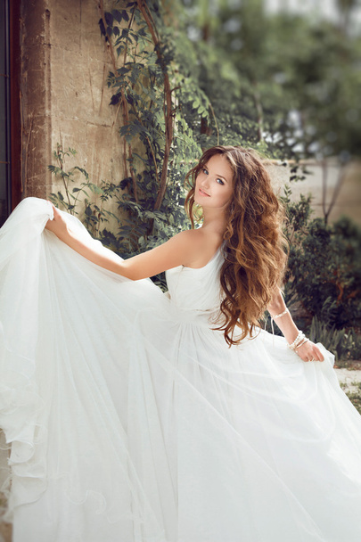 Beauty fashion bride girl gamboling with wedding blowing dress, - Foto, afbeelding