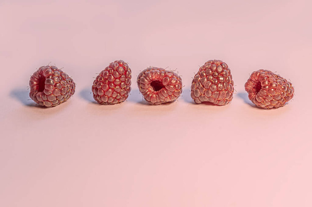 frambuesas maduras dulces en una superficie rosa de cerca - Foto, imagen