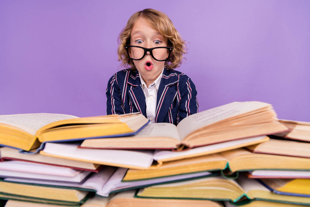 Ritratto di attraente divertente concentrato stupito ragazzo lettura pile libro broncio labbra isolate su viola viola colore sfondo - Foto, immagini