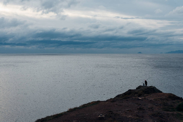 siluetit ihmiset katselevat merelle kivinen kannustaa - Valokuva, kuva