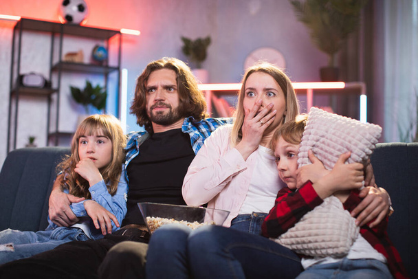 Family getting frightened while watching horror movie - Valokuva, kuva