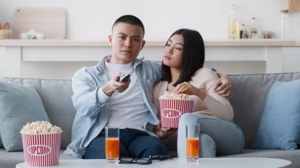 Nespokojený korejský pár Sledování televize přepínání kanálů doma - Záběry, video