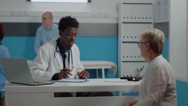Африканський американський лікар пише медогляд на записнику - Кадри, відео