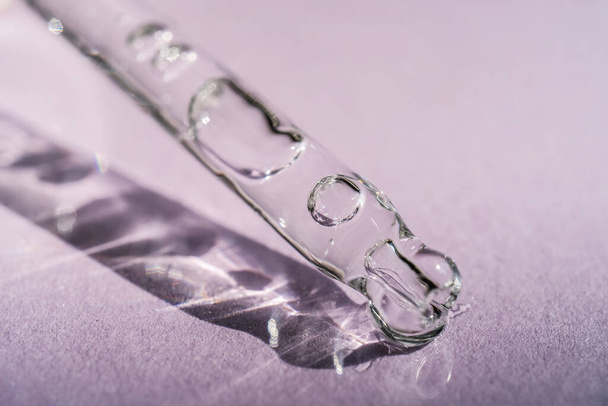 A cosmetic product flows out of a pipette with bubbles. - Photo, Image