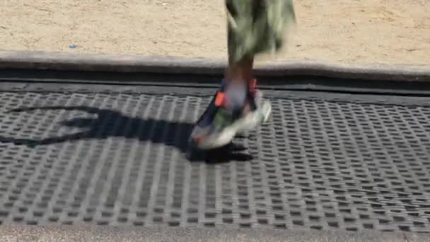 Kid jumping, kid jumping no trampolim no playground, luz solar e sombra - Filmagem, Vídeo