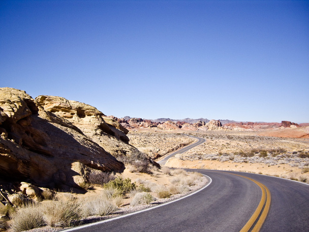 lange en bochtige woestijn weg curven in de verte - Foto, afbeelding