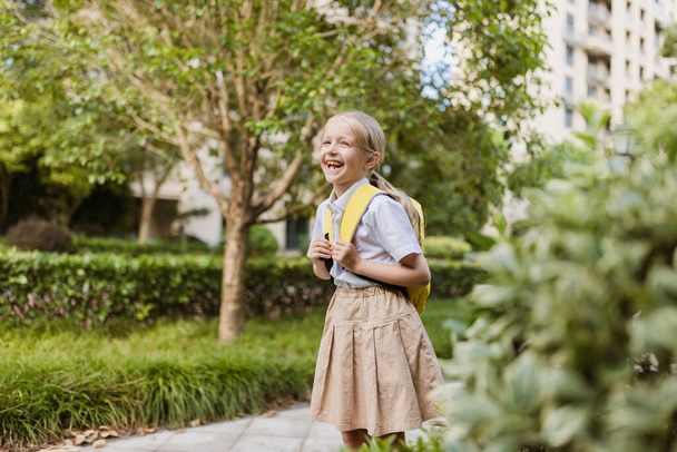 Schoolgirl back to school after summer vacations. Pupil in uniform smiling early morning outdoor.  - Φωτογραφία, εικόνα