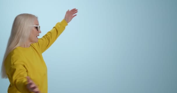 Mujer madura jugando charadas sobre fondo de color - Metraje, vídeo
