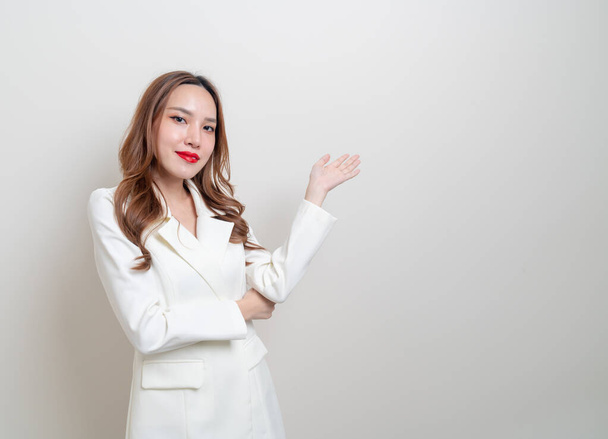 portrait beautiful Asian business woman with hand presenting or pointing on white background - Foto, imagen
