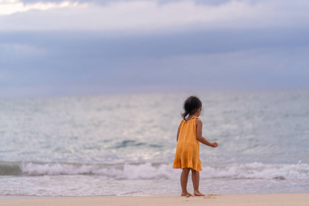 A back view of a cute little Thai girl at the beach - Fotó, kép