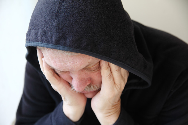 szomorú idősebb férfi kapucnis kabát - Fotó, kép