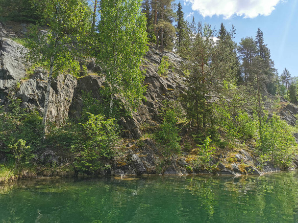 Vista de las costas rocosas y el agua esmeralda del Cañón del Mármol en el Ruskeala Mountain Park en un soleado día de verano. - Foto, Imagen