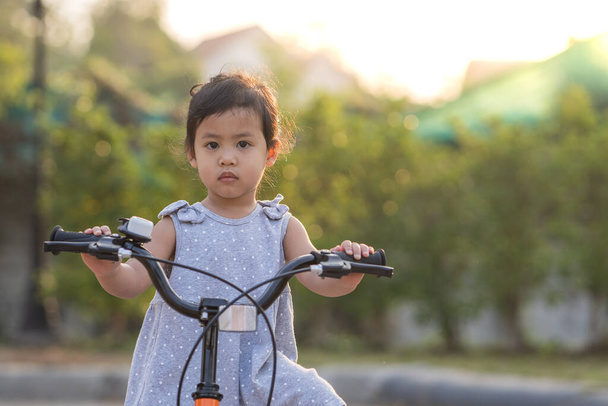 A cute little Thai girl riding a bicycle - Valokuva, kuva