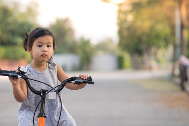 A cute little Thai girl riding a bicycle - Valokuva, kuva