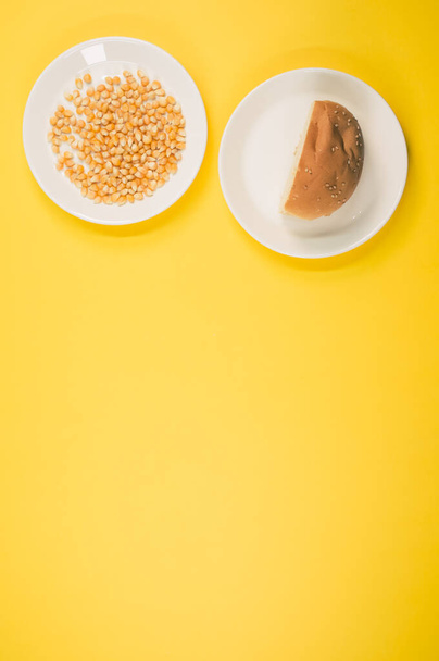 A vertical shot of corn and half bread on a yellow background - Foto, imagen