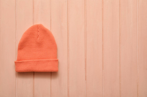 Stijlvolle warme hoed op houten achtergrond - Foto, afbeelding