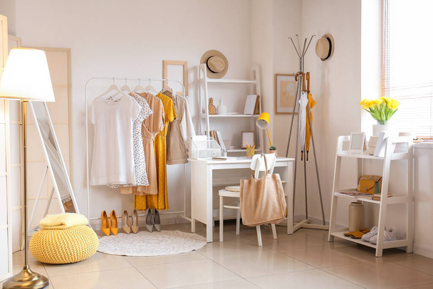 Interior of room with modern workplace and stylish female clothes - Photo, Image