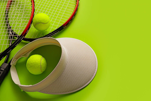 Visor, raquetas de tenis y pelotas sobre fondo de color - Foto, imagen