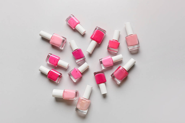 Scattered bottles of nail polishes on light background - Фото, зображення