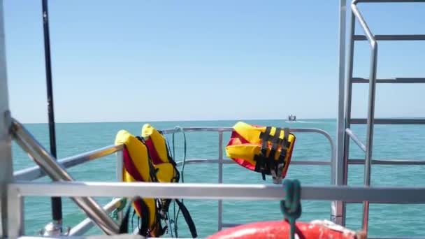 Casacos salva-vidas laranja brilhante no barco em mar aberto. POV de ponte ou proa de navio. Velocidade de navegação rápida barco deslizando sobre o mar ou oceano. Avançar no mar em grande iate à vela branco. Ondas finas ao longo - Filmagem, Vídeo