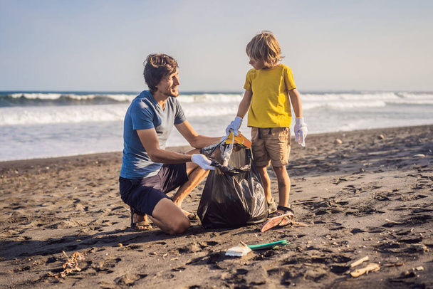 Isä ja poika siivoavat rantaa. Lasten luonnollinen koulutus - Valokuva, kuva