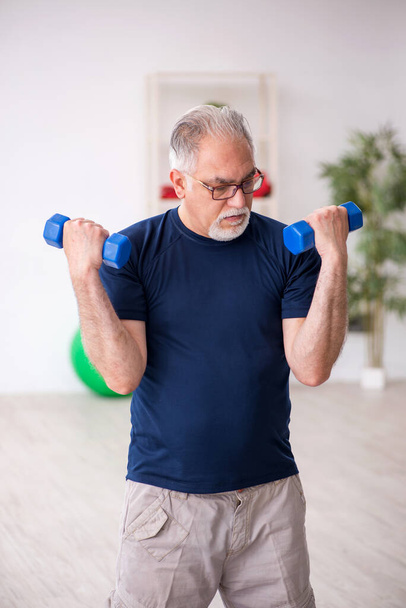 Старик занимается спортом в помещении - Фото, изображение
