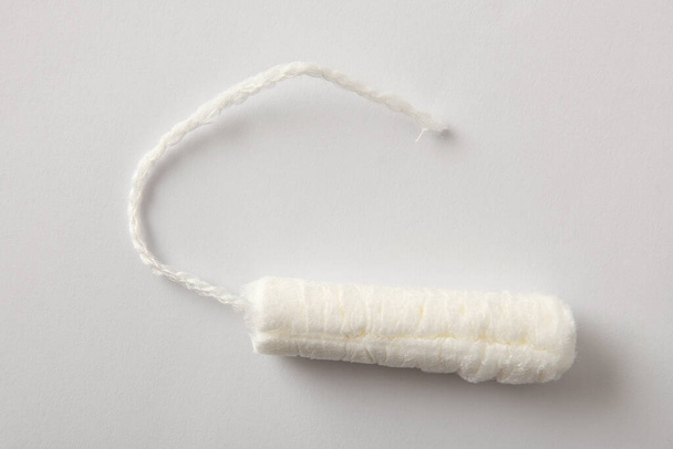 Absorbent protective and absorbent cotton tampon for women's care on white background. Top view. Horizontal composition. - Photo, image