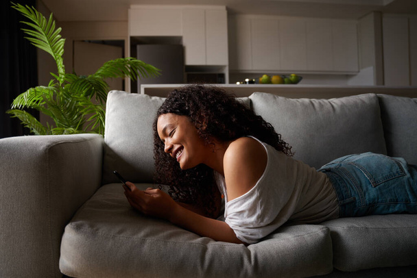 Mixed race female student working from home texting on cellular device - Fotoğraf, Görsel