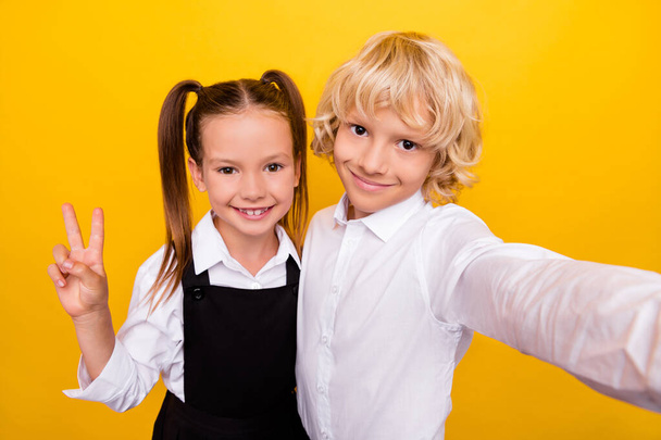 Photo of cheerful friendly classmate kids take selfie show v-sign wear school uniform isolated yellow color background - Foto, Bild