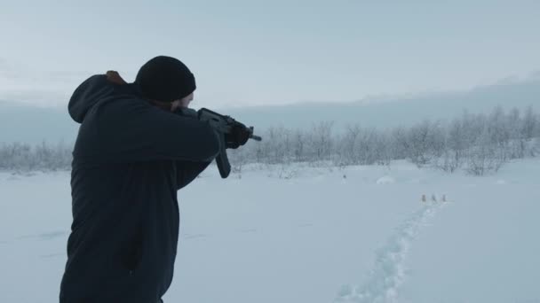 Regione di Murmansk, Russia - 10 gennaio 2021: Un uomo spara a bersagli mentre è in piedi in un campo innevato. Rallentatore - Filmati, video