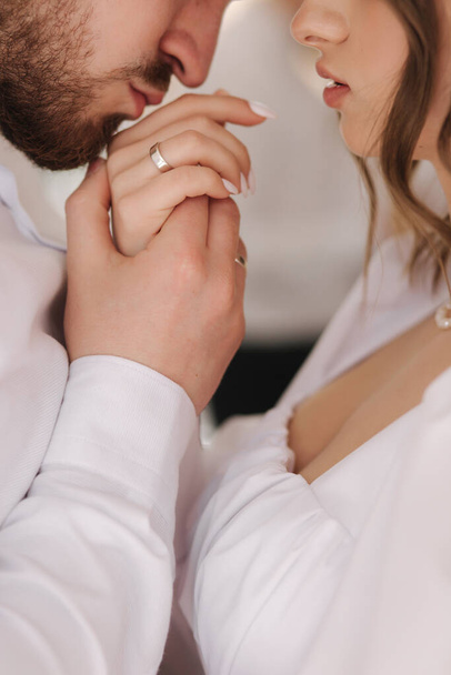 Close up of groom kiss his brides hand. Tender kiss of handsome man. Elegant female give hand to her husband - Zdjęcie, obraz