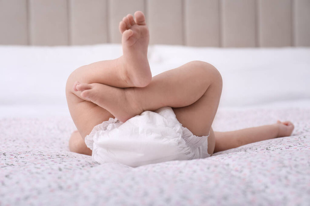 Little baby in diaper on bed, closeup - Фото, изображение