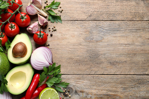 Fresh guacamole ingredients on wooden table, flat lay. Space for text - Foto, Bild