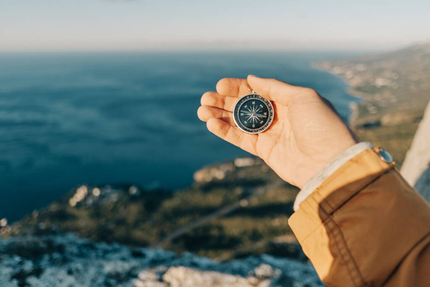 Traveler in the mountains uses a compass. - Foto, afbeelding
