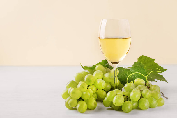 Glass of white wine and white grape on wooden table. Wine composition with copy space for design. Still life of wine and grape. - Фото, изображение
