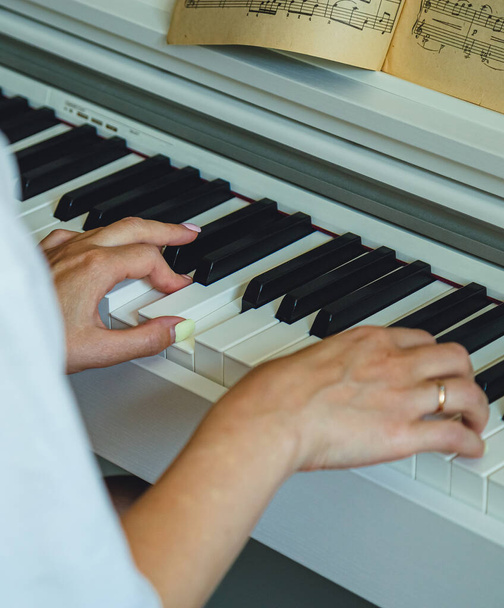 Молода жінка грає на піаніно. Руки і ключі крупним планом
 - Фото, зображення