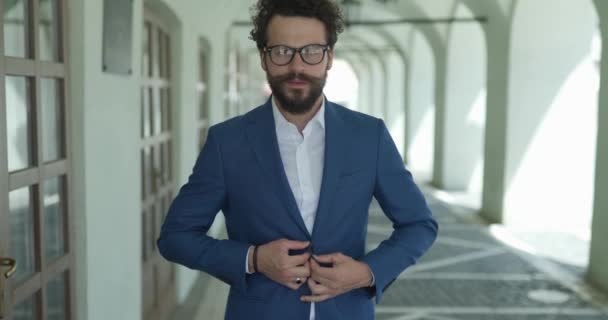 szexi okos alkalmi férfi fogja kéz a kabát gombot, és állítsa be, miközben mosolyog, amikor a kamera nagyítás kívül - Felvétel, videó