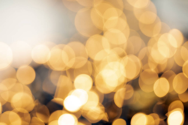 Defocused gold light abstract Christmas or Holiday background texture, sparkling yellow blurred warm tones colorful - Photo, Image