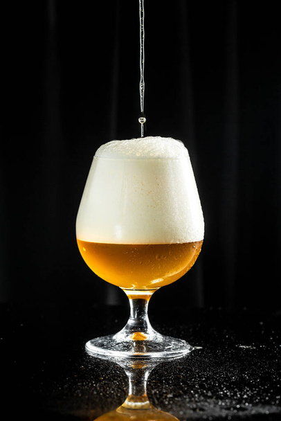 Beer. pouring beer into glass, with thick foam. - Foto, Bild