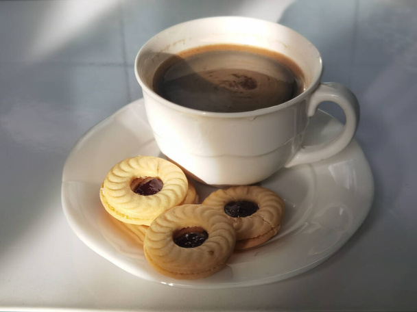 Biscuits au pain avec café noir sur fond blanc - Photo, image
