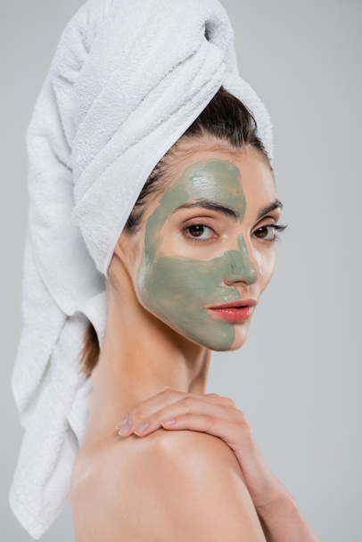 young woman with towel on head and clay mask on face isolated on grey - Foto, Imagem