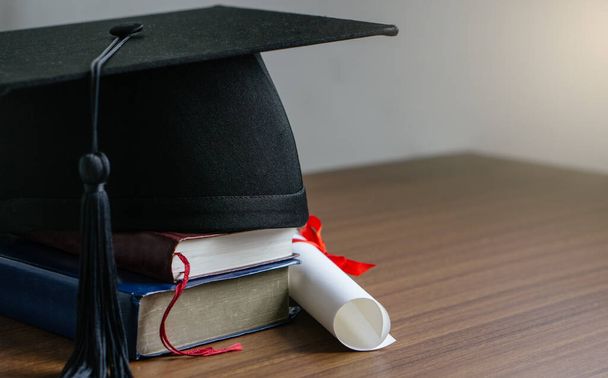 Close up mortar board with degree paper on wood table. graduation concept. - Photo, Image
