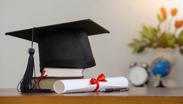 Placa de argamassa com papel de grau e livros sobre mesa de madeira. conceito de graduação. - Foto, Imagem