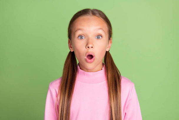 Photo of amazed shocked positive small girl astonished news reaction isolated on shine green color background - Photo, Image